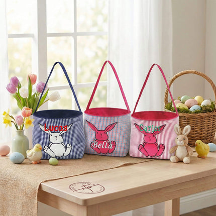 Red To Purple bunny applique Easter baskets with custom name embroidery, styled on a wood desk with Easter eggs