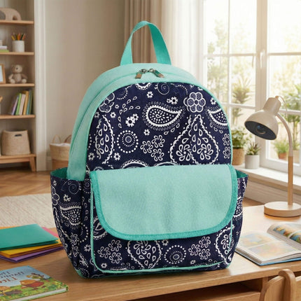 Red To Purple personalized preschool backpack in navy-white paisley pattern and mint accents on desk.