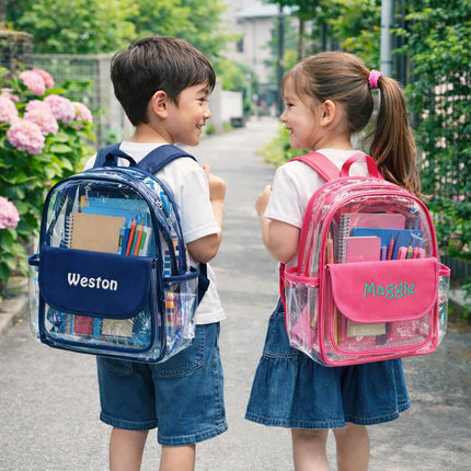 Two children with clear backpacks, one navy and one pink, standing outdoors.