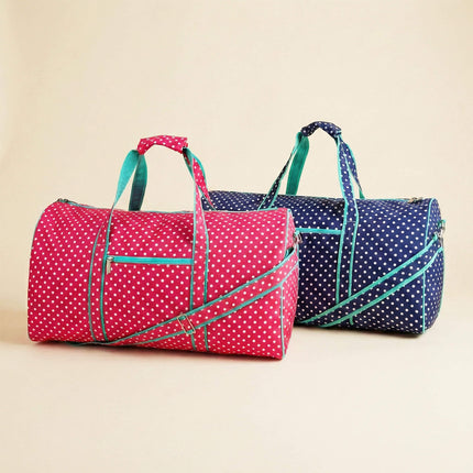 Two polka dot duffel bags, one red and one blue, on a beige background.