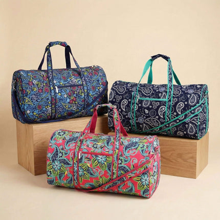 Three colorful duffel bags with different paisley patterns on a beige background